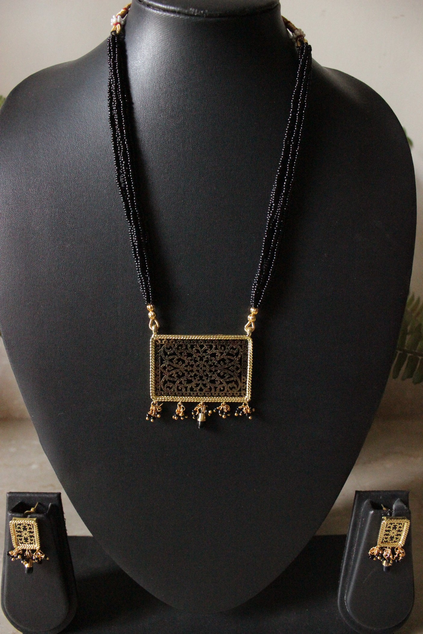 Intricately Detailed Gold Toned Rectangular Pendant Necklace Set with Multi-Layer Black Beads Closure