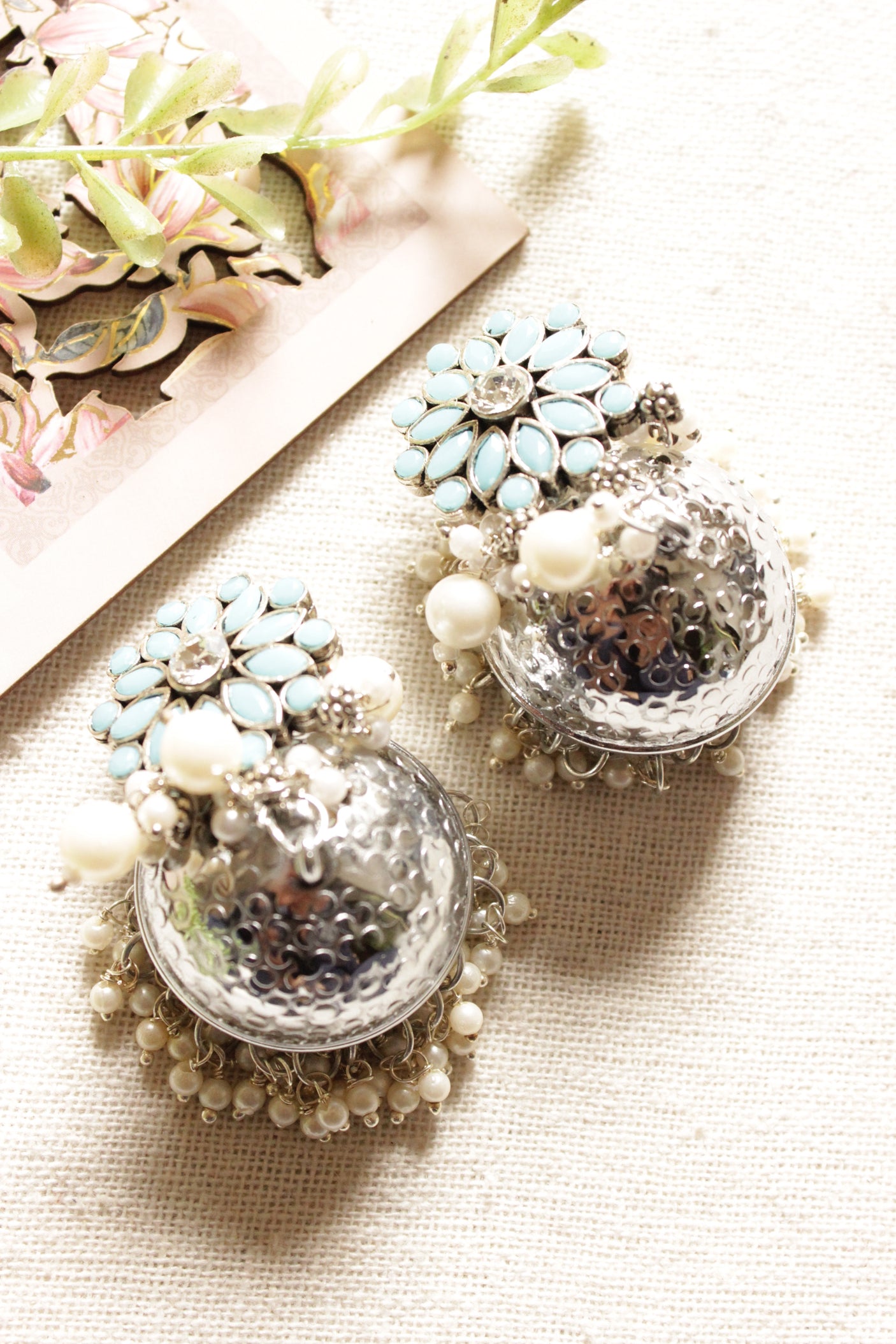 Turquoise Glass Stones Embedded Silver Finish Jhumka Earrings