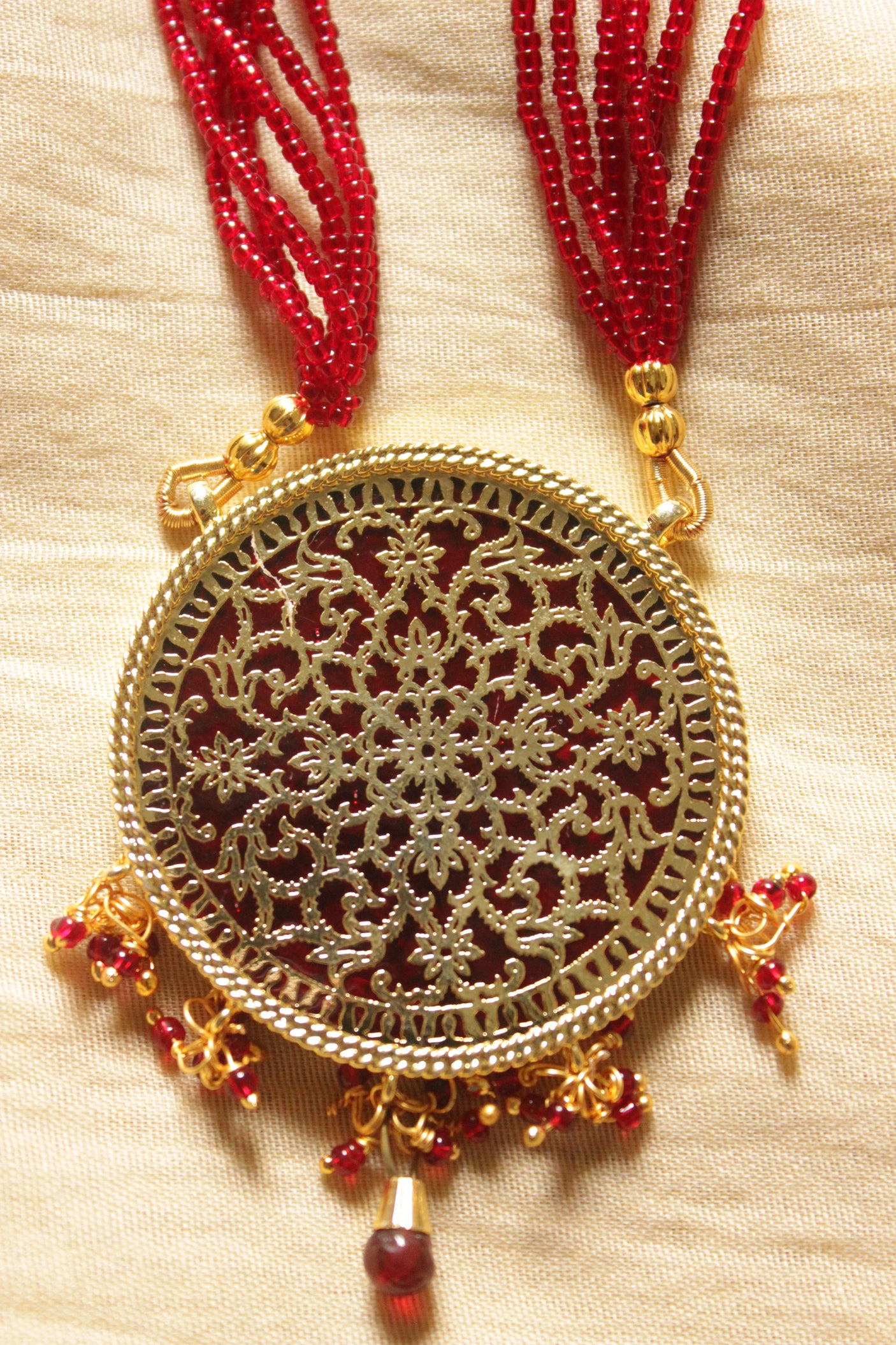 Intricately Detailed Gold Toned Pendant Necklace Set with Multi-Layer Red Beads Closure
