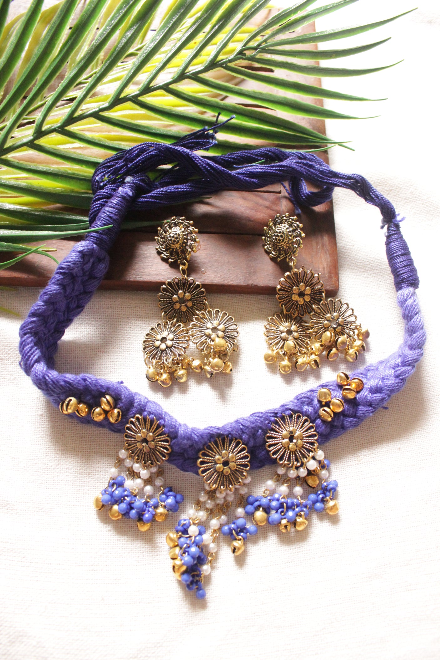 Purple Braided Threads Necklace Set Embellished with Antique Gold Finish Flower Motifs Metal Charms