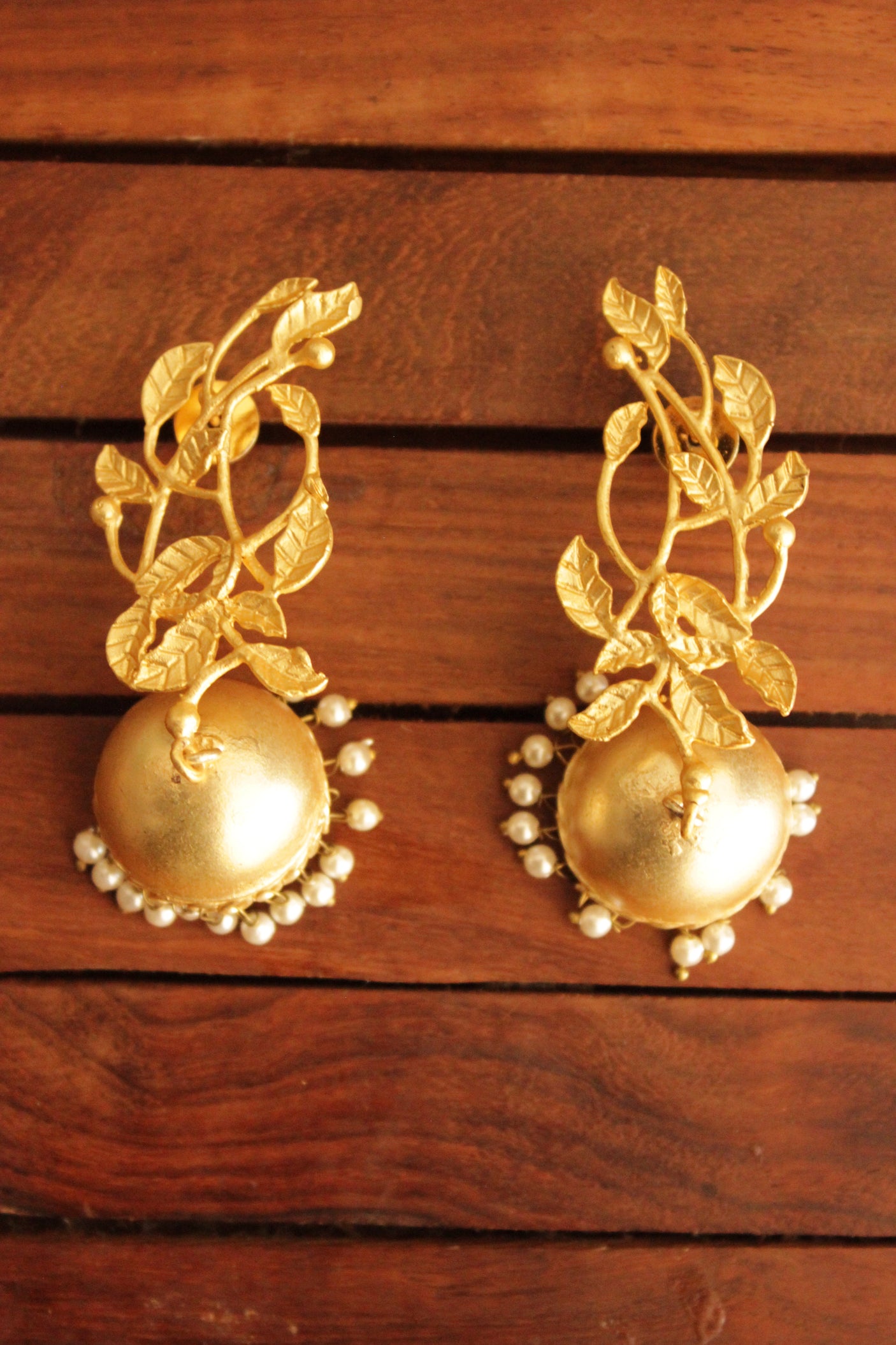 Leaf Motifs Gold Toned Brass Dangler Jhumka Earrings Accentuated with White Beads