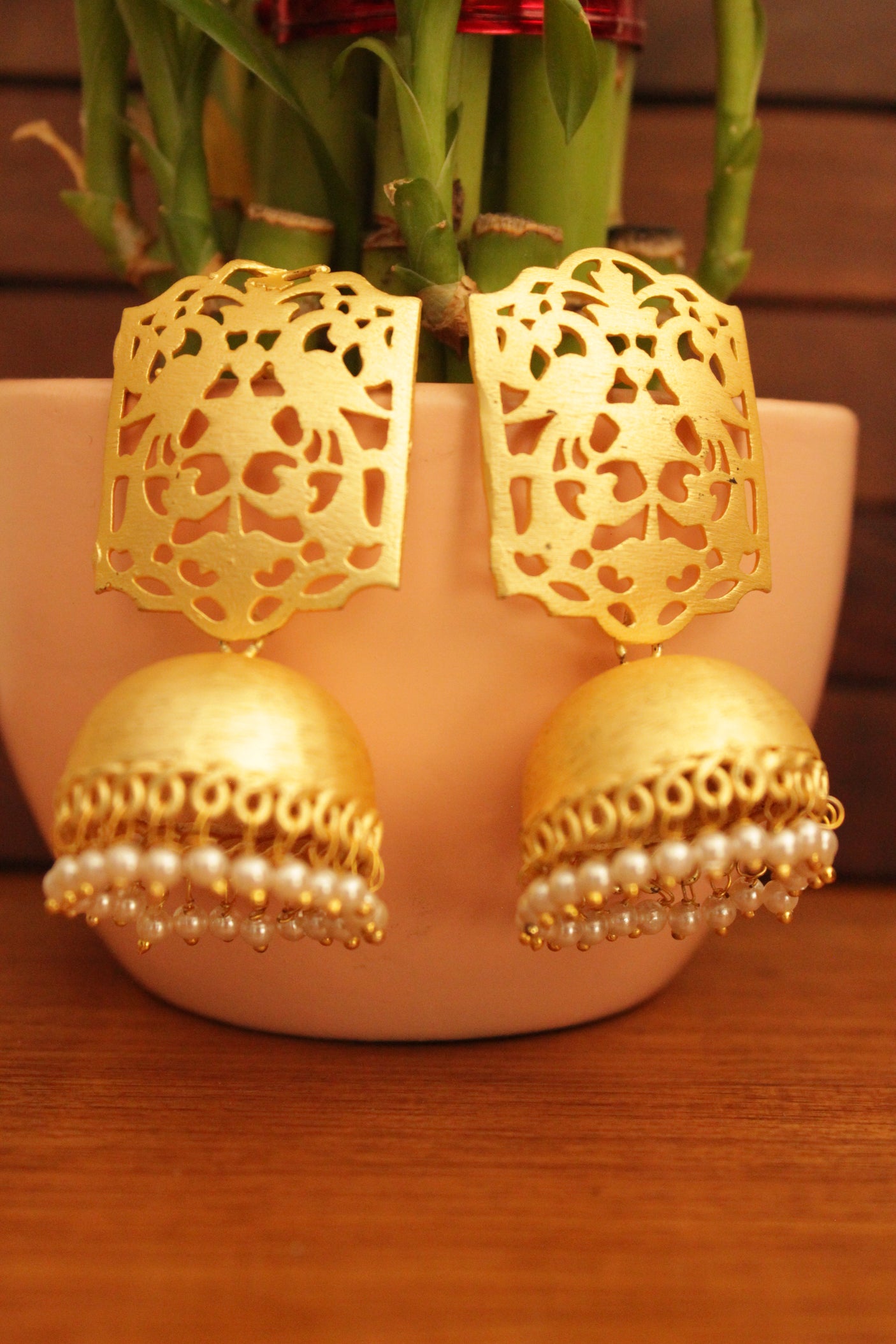 Jaali Pattern Gold Toned Handmade Jhumka Earrings Accentuated with White Beads