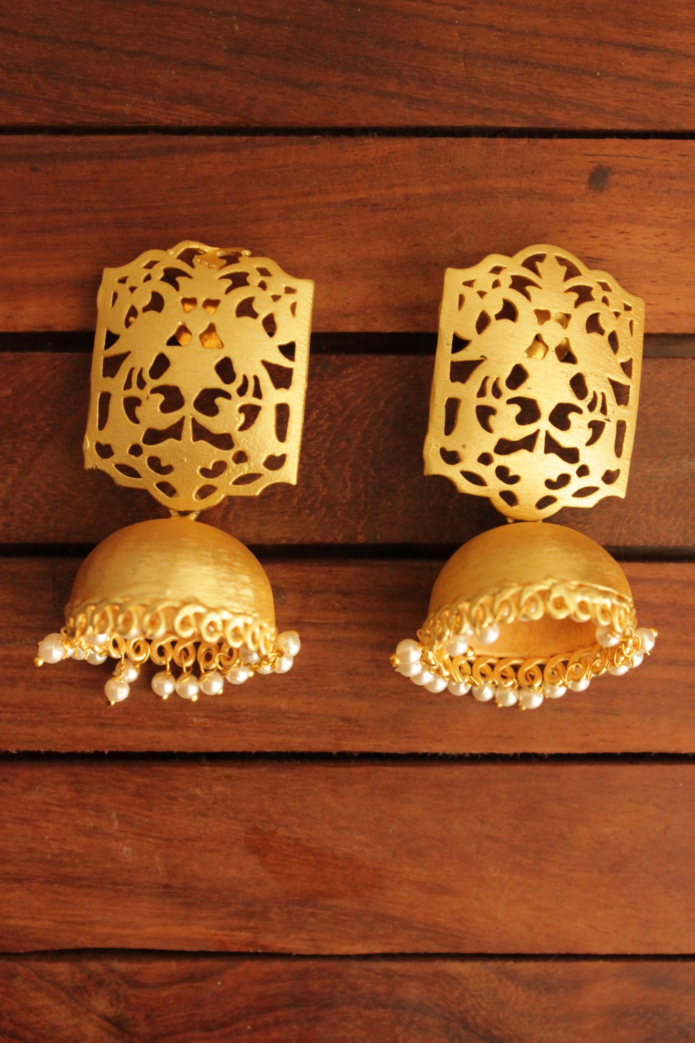 Jaali Pattern Gold Toned Handmade Jhumka Earrings Accentuated with White Beads