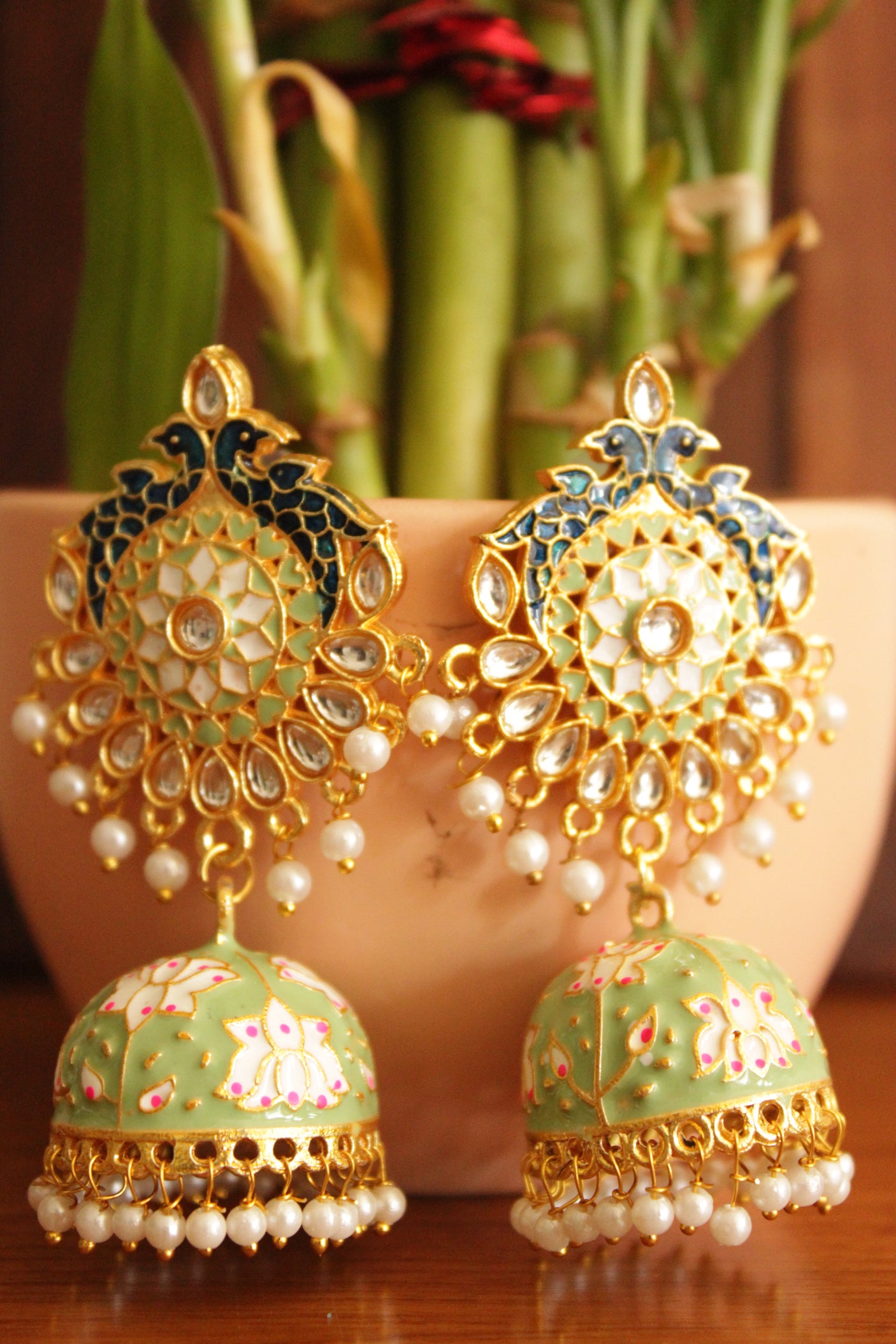 Elaborate Kundan Stones Embedded Gold Toned Hand Painted Peacock Motifs Mint Green Meenakari Jhumka Earrrings