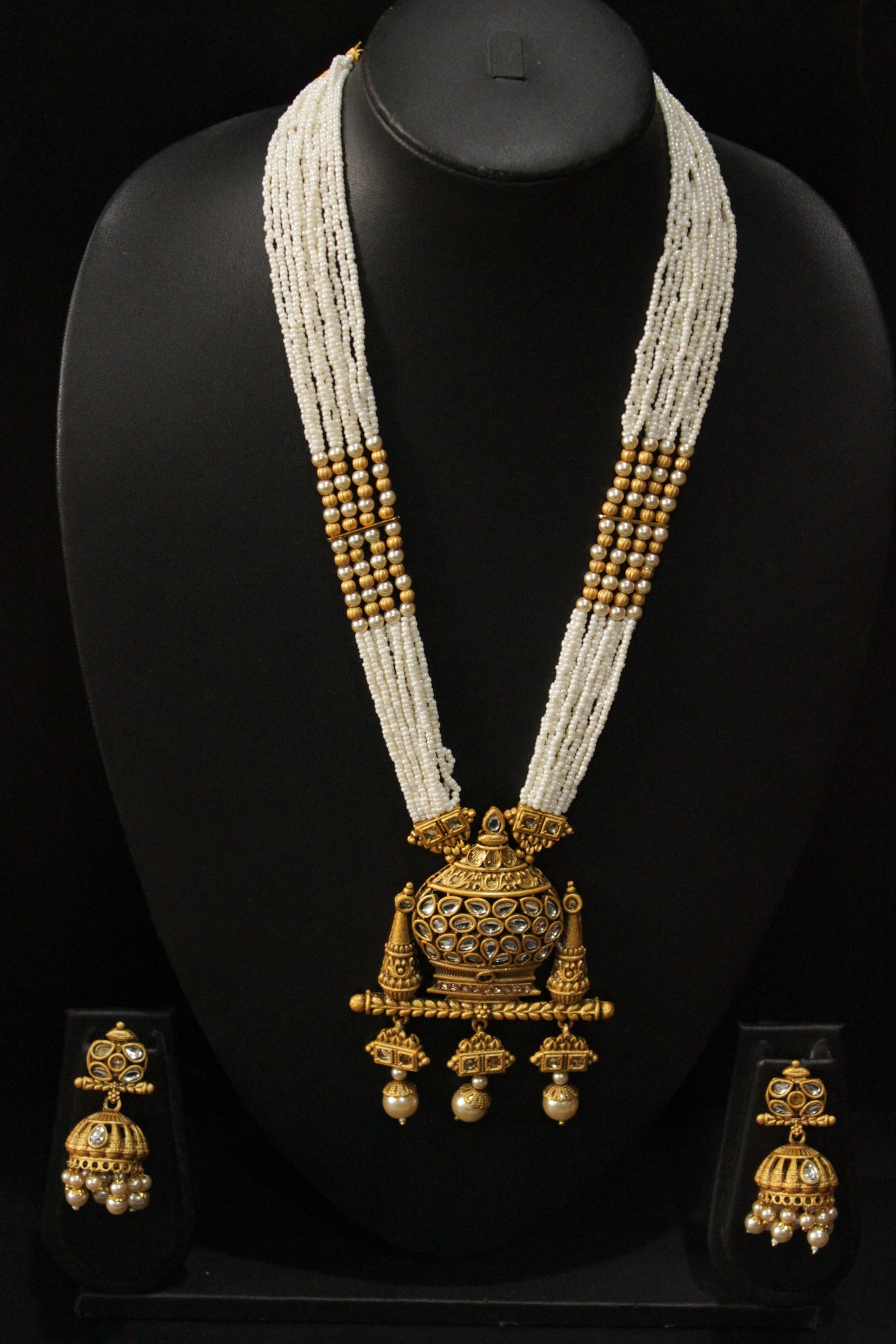 Kundan Stones Embedded Kalash Motif Matt Gold Finish Multi-Layer White Beads Long Necklace Set with Jhumka Earrings