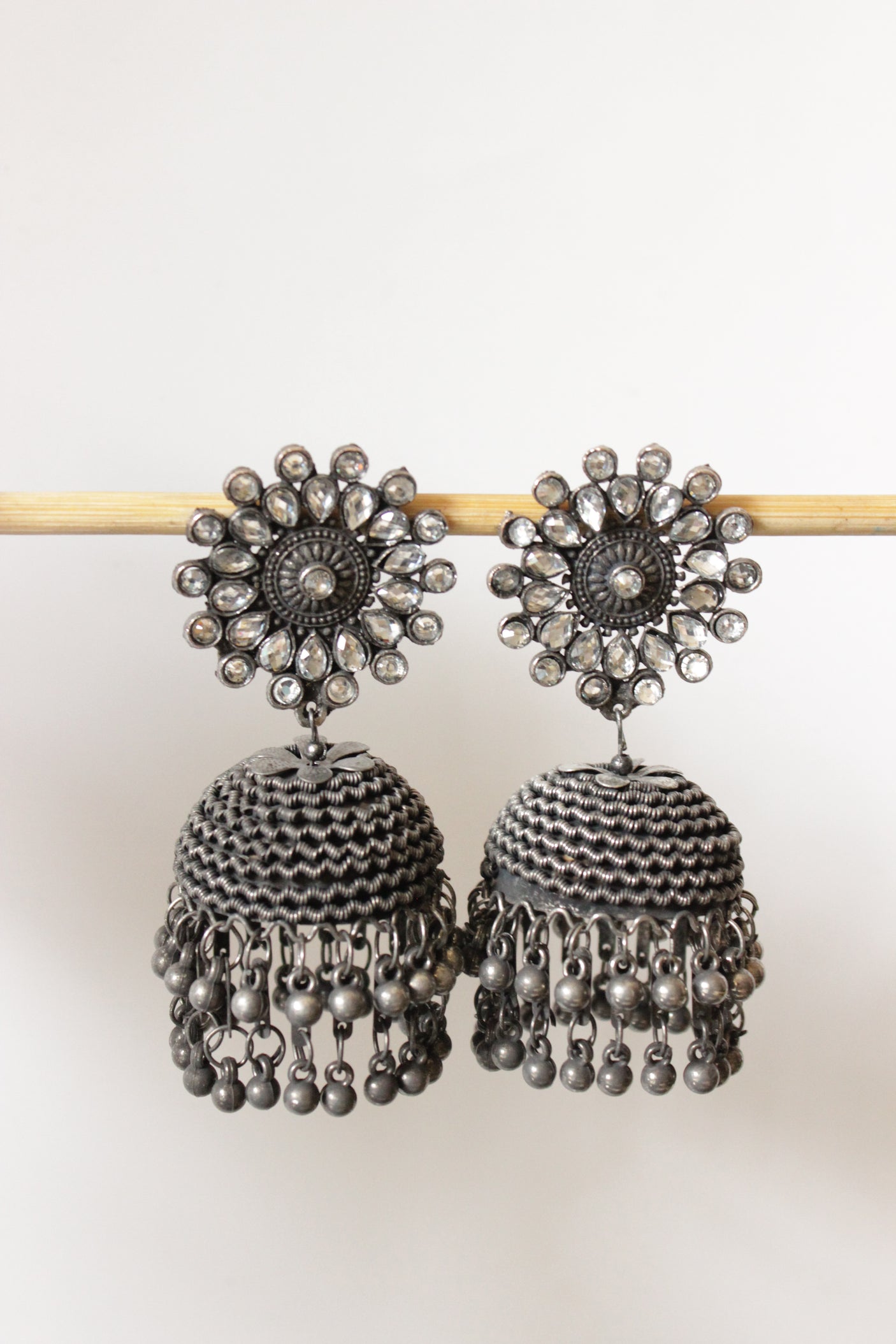 White Glass Stones Embedded Oxidised Finish Jhumkas with Bead Strings