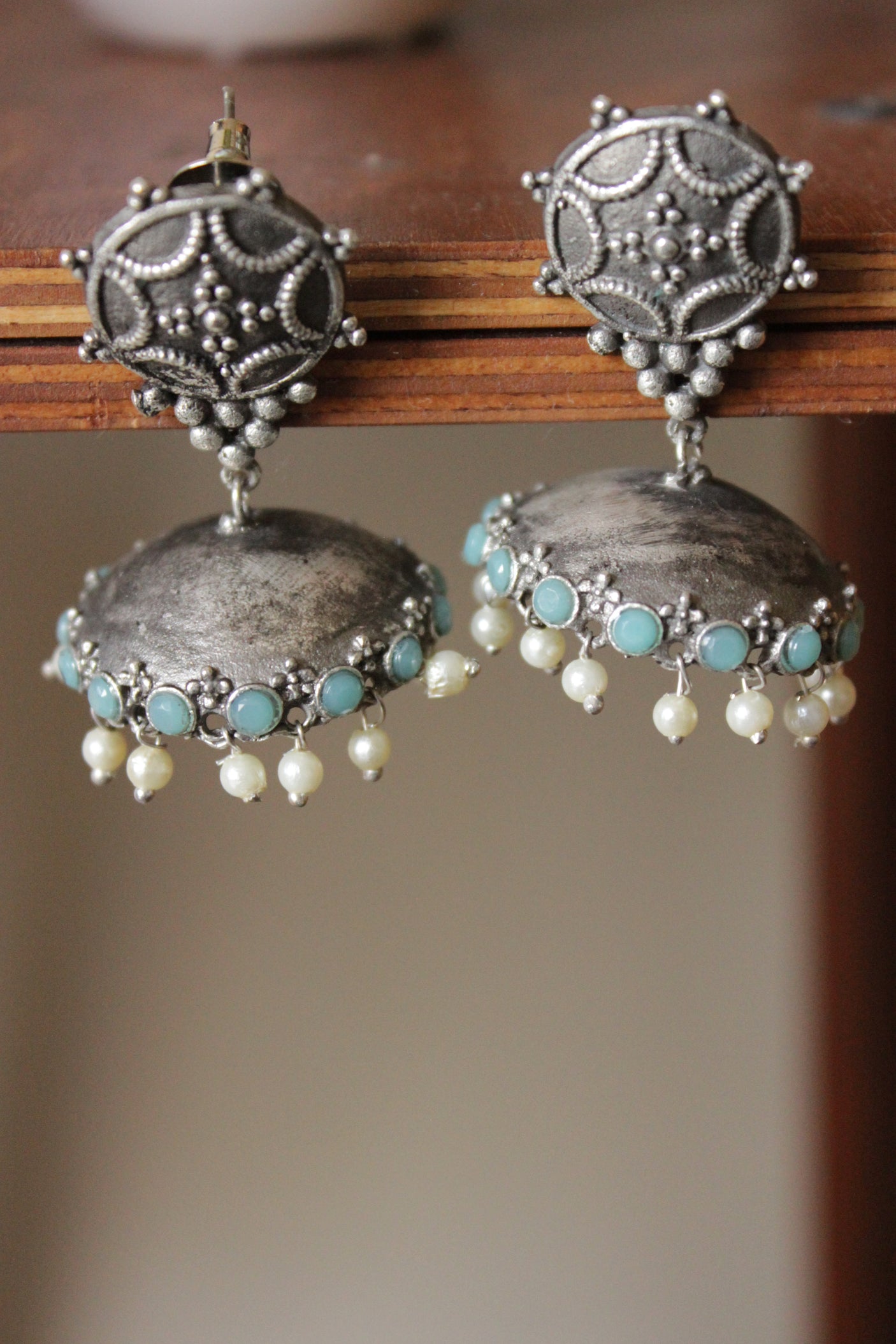 Turquoise Glass Stones Embedded Premium Oxidised Finish Jhumka Earrings Embellished with White Beads