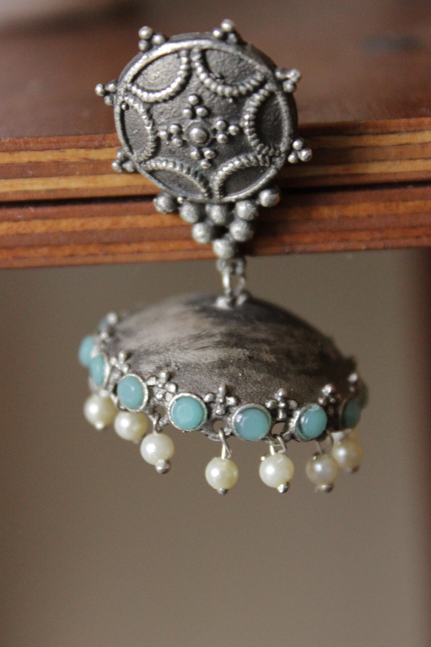 Turquoise Glass Stones Embedded Premium Oxidised Finish Jhumka Earrings Embellished with White Beads