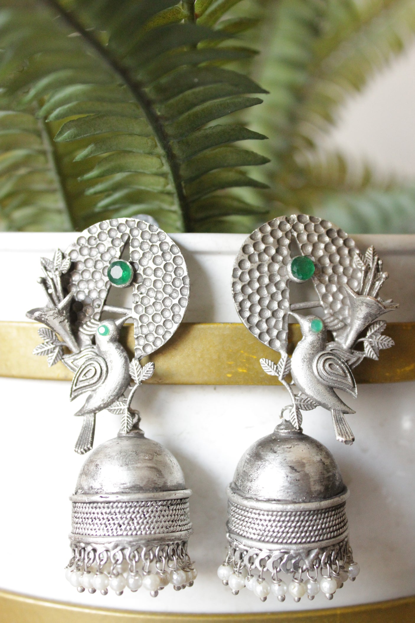 Green Stones Embedded Silver Finish Peacock Motif Statement Jhumka Earrings Accentuated with White Beads