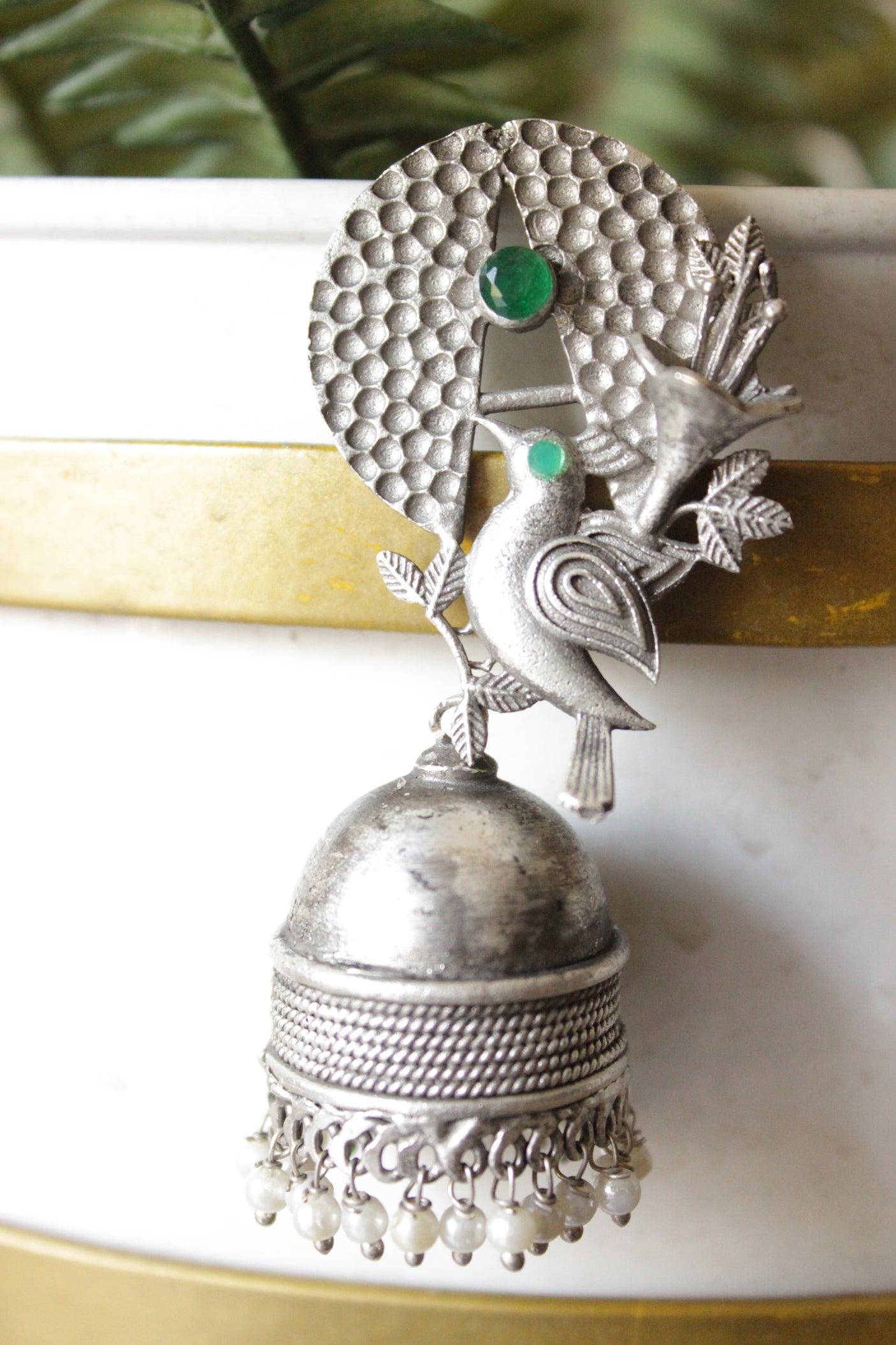 Green Stones Embedded Silver Finish Peacock Motif Statement Jhumka Earrings Accentuated with White Beads
