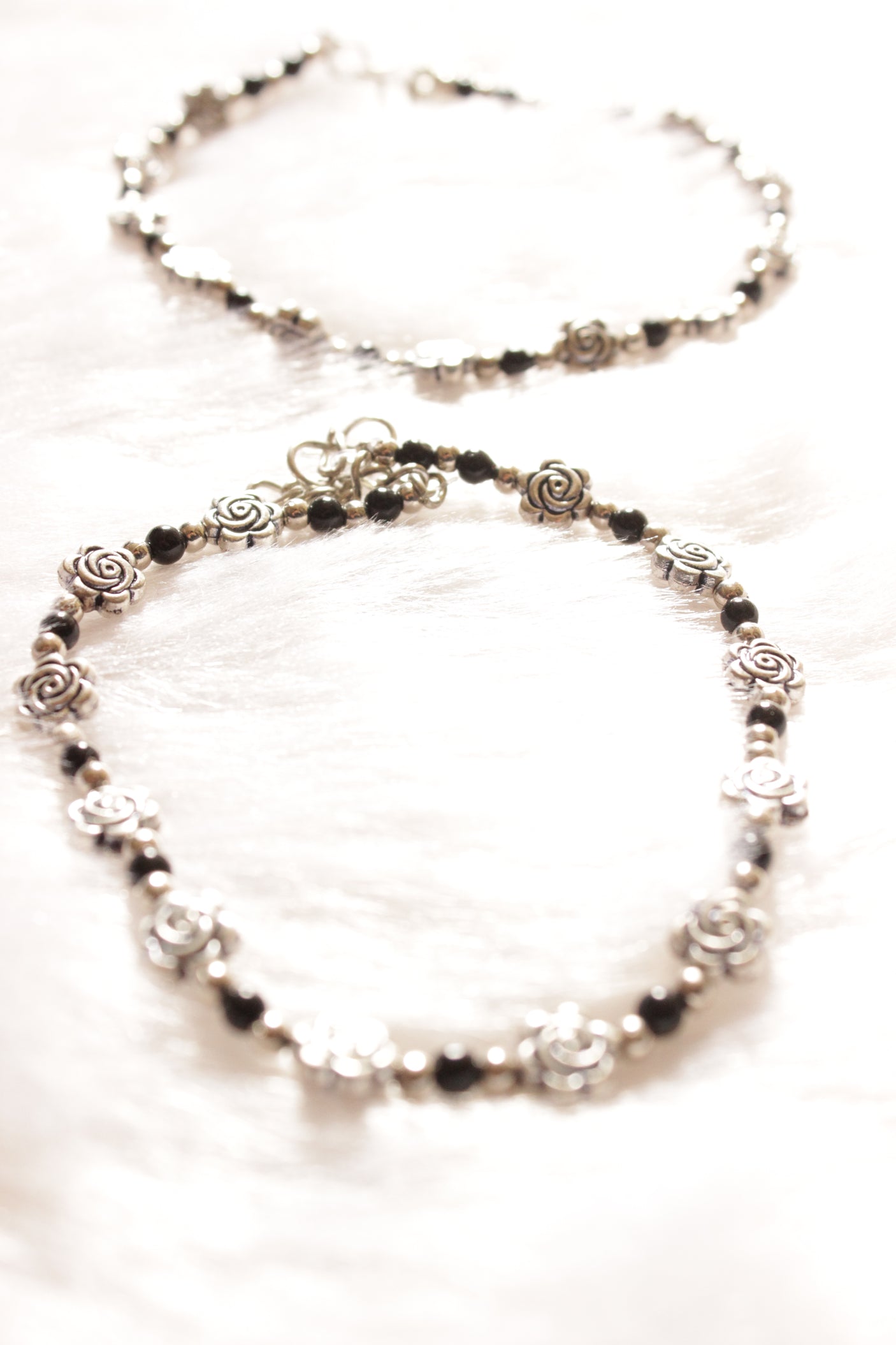 Silver Finish Flower Motif Charms Intertwined with Black Beads Set of 2 Anklets