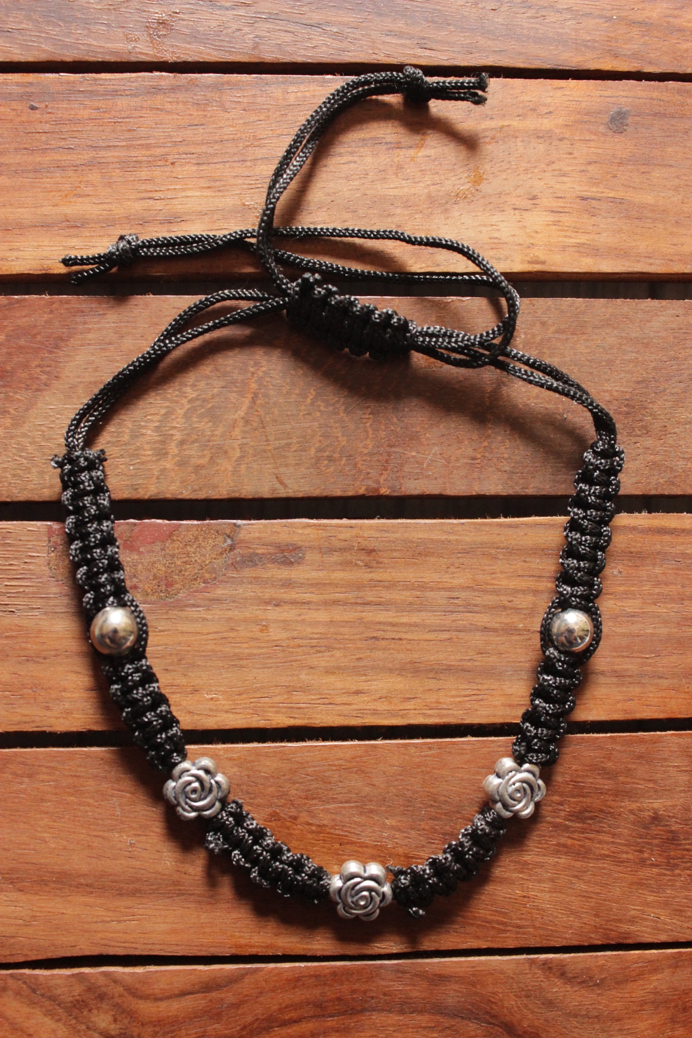 Silver Finish Flower Motif Charms Braided in Black Silk Threads Anklet