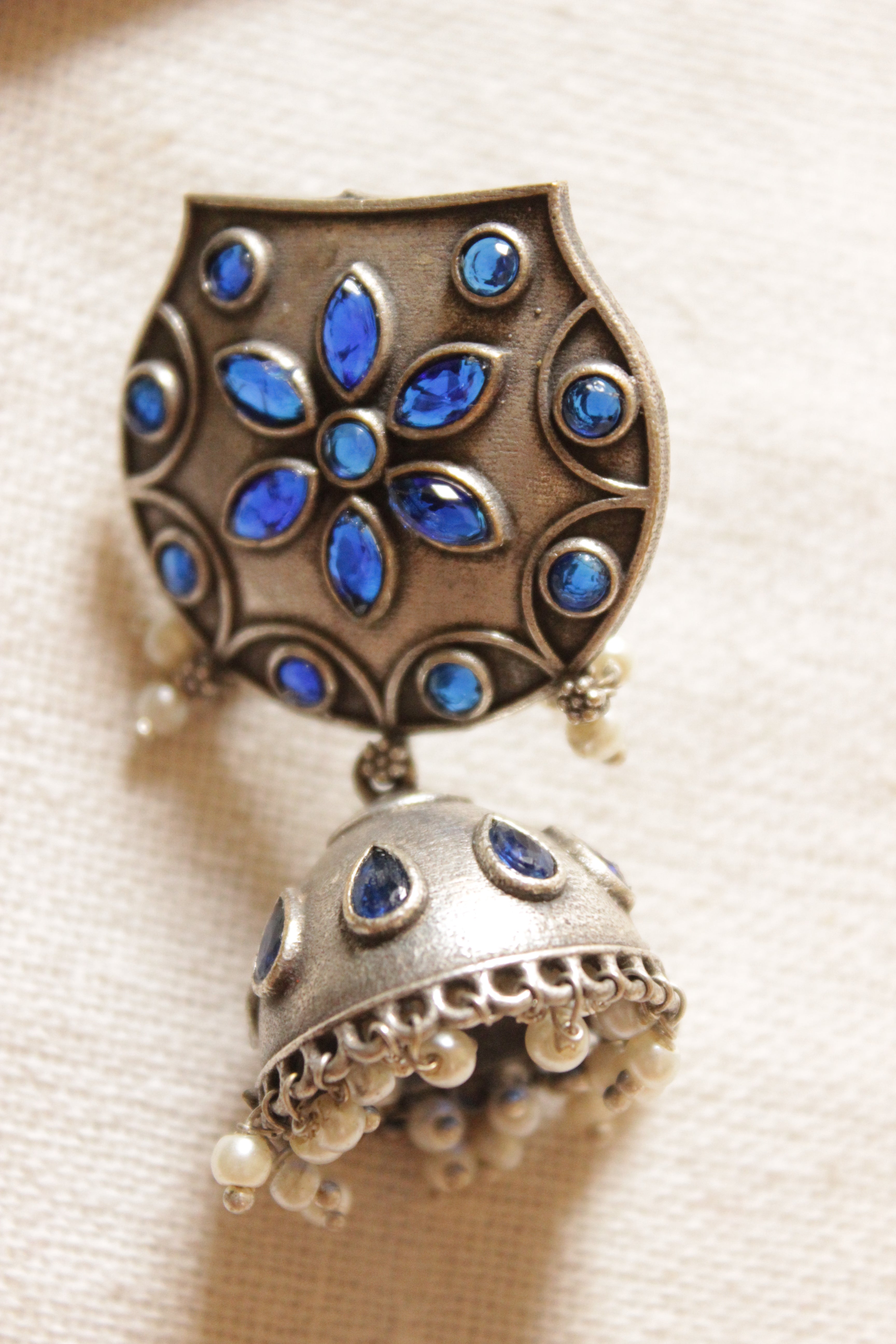 Premium Oxidised Finish Blue Stones Embedded White Beads Embellished Jhumka Earrings
