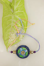 Load image into Gallery viewer, Fabric and Terracotta Clay Hand Painted Flower Motifs Rakhi
