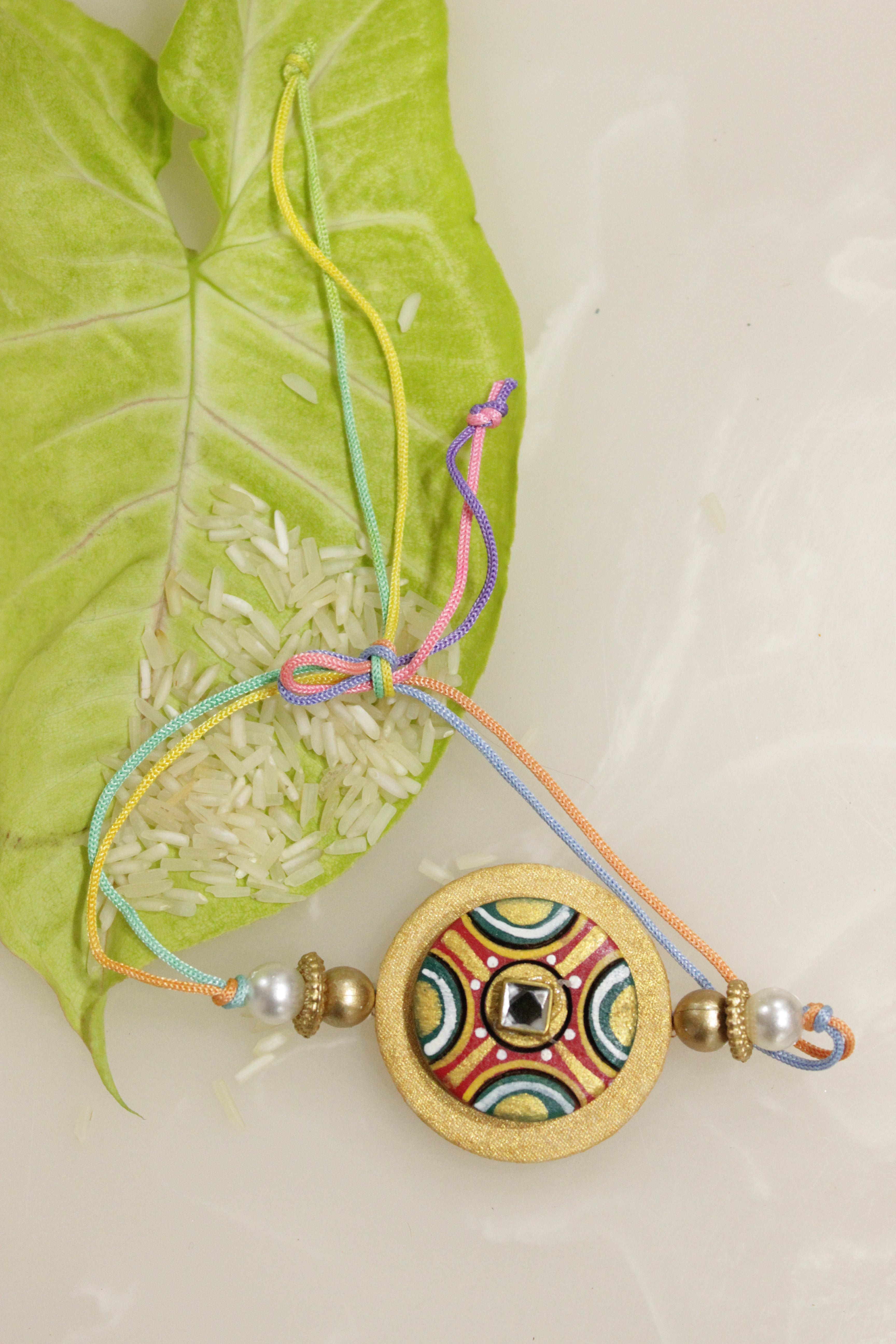 Fabric and Terracotta Clay Golden Hand Painted Rakhi