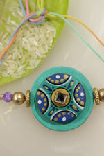 Load image into Gallery viewer, Fabric and Terracotta Clay Turquoise Hand Painted Rakhi
