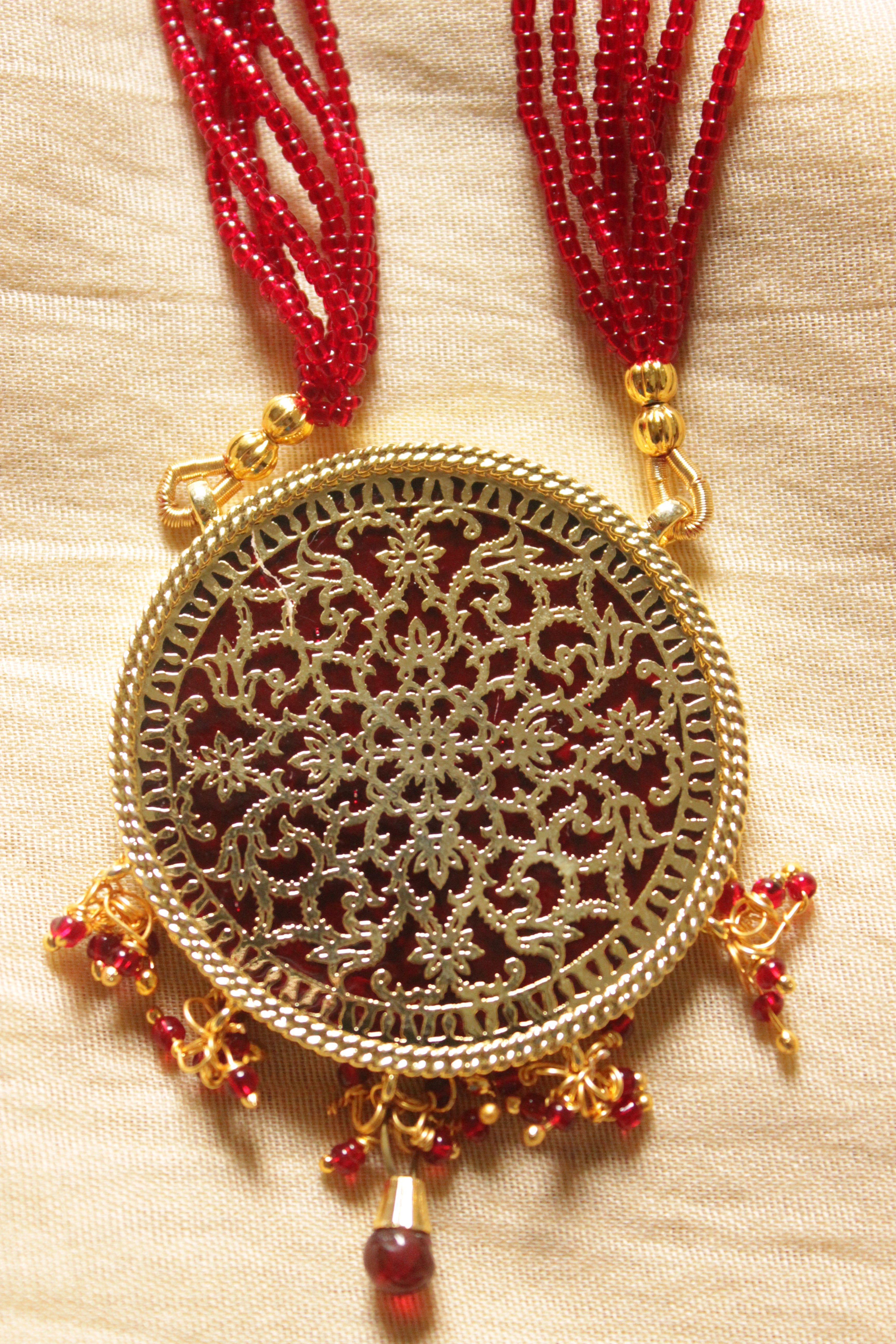 Intricately Detailed Gold Toned Pendant Necklace Set with Multi-Layer Red Beads Closure