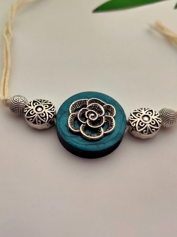Intricately Detailed Blue Wood and Metal Rakhi with Off-White Cotton Thread