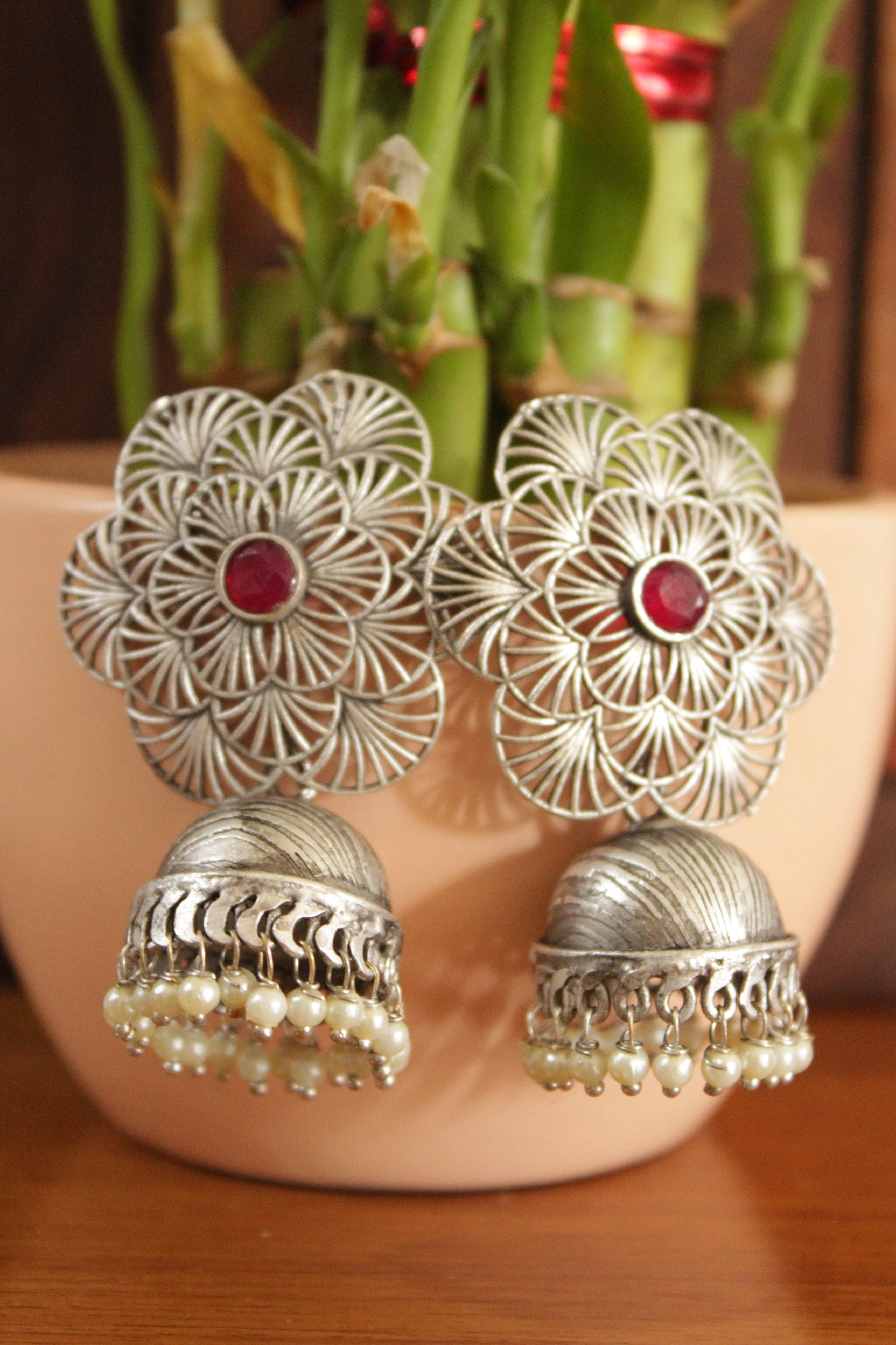 Detailed Jaali Pattern Flower Stud Silver Finish Jhumka Earrings with Red Center Stone