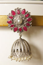 Load image into Gallery viewer, Ruby Red Natural Gemstones Embedded Silver Finish Flower Motif Brass Jhumka Earrings
