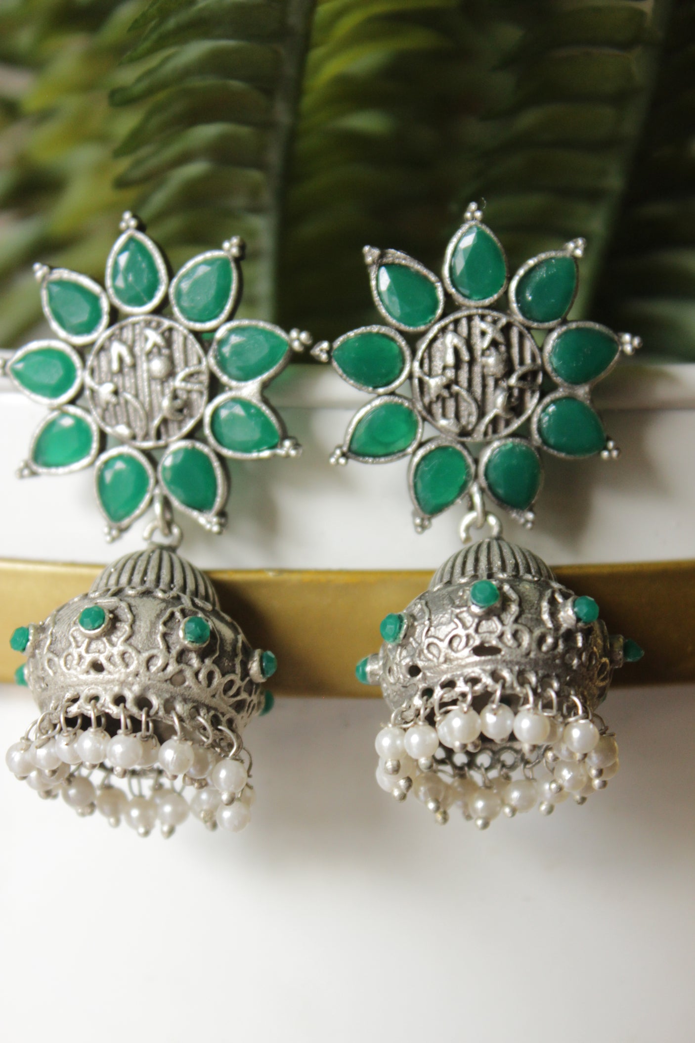 Bottle Green Glass Stones Embedded Silver Finish Flower Motif Dangler Jhumka Earrings in Brass