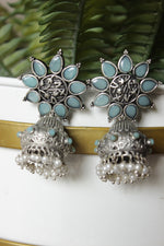 Load image into Gallery viewer, Turquoise Glass Stones Embedded Silver Finish Flower Motif Dangler Jhumka Earrings in Brass
