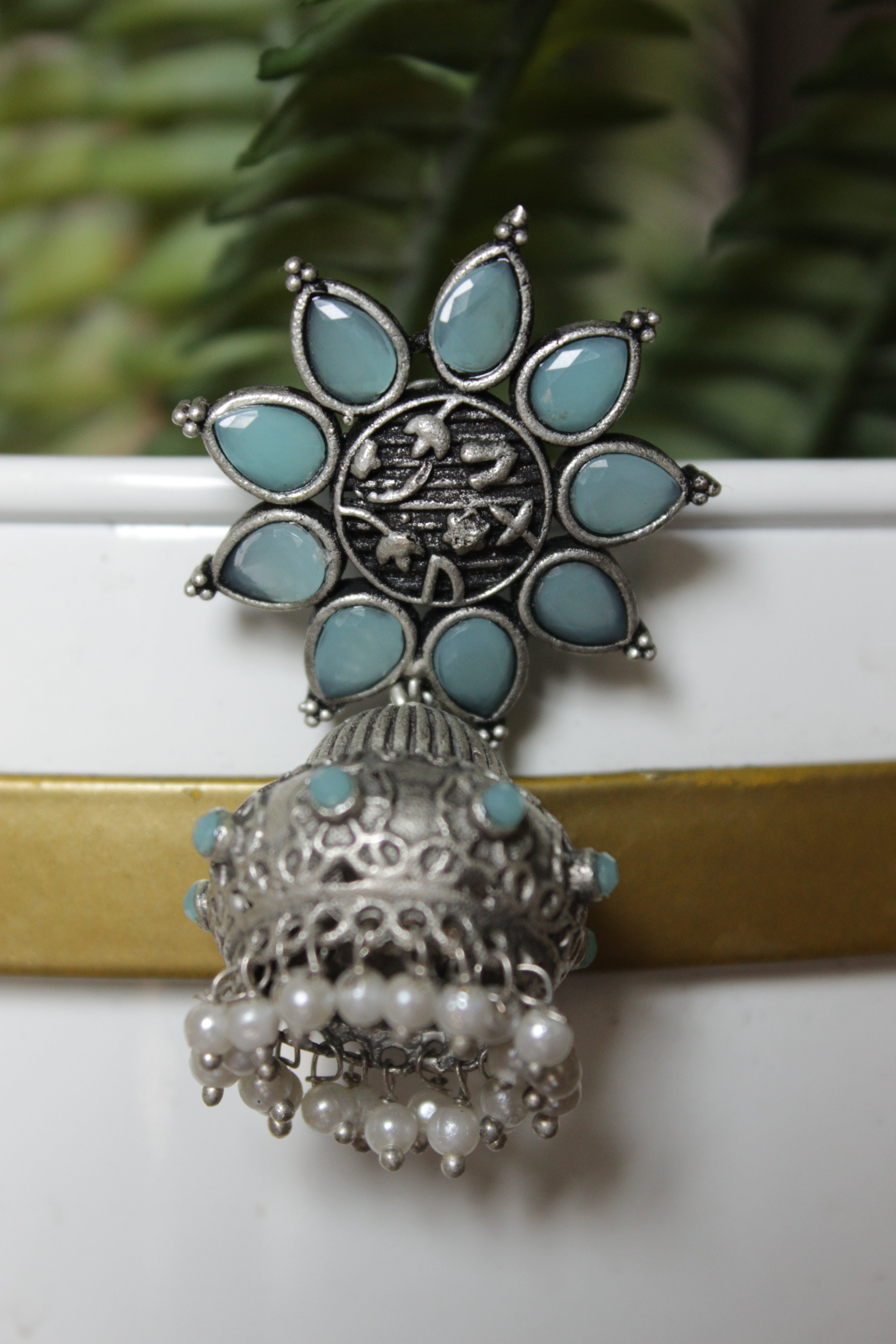 Turquoise Glass Stones Embedded Silver Finish Flower Motif Dangler Jhumka Earrings in Brass