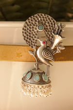 Load image into Gallery viewer, Turquoise Stones Embedded Silver Finish Peacock Motif Statement Dangler Earrings Accentuated with White Beads
