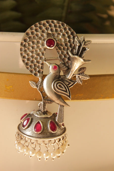 Red Stones Embedded Silver Finish Peacock Motif Statement Dangler Earrings Accentuated with White Beads