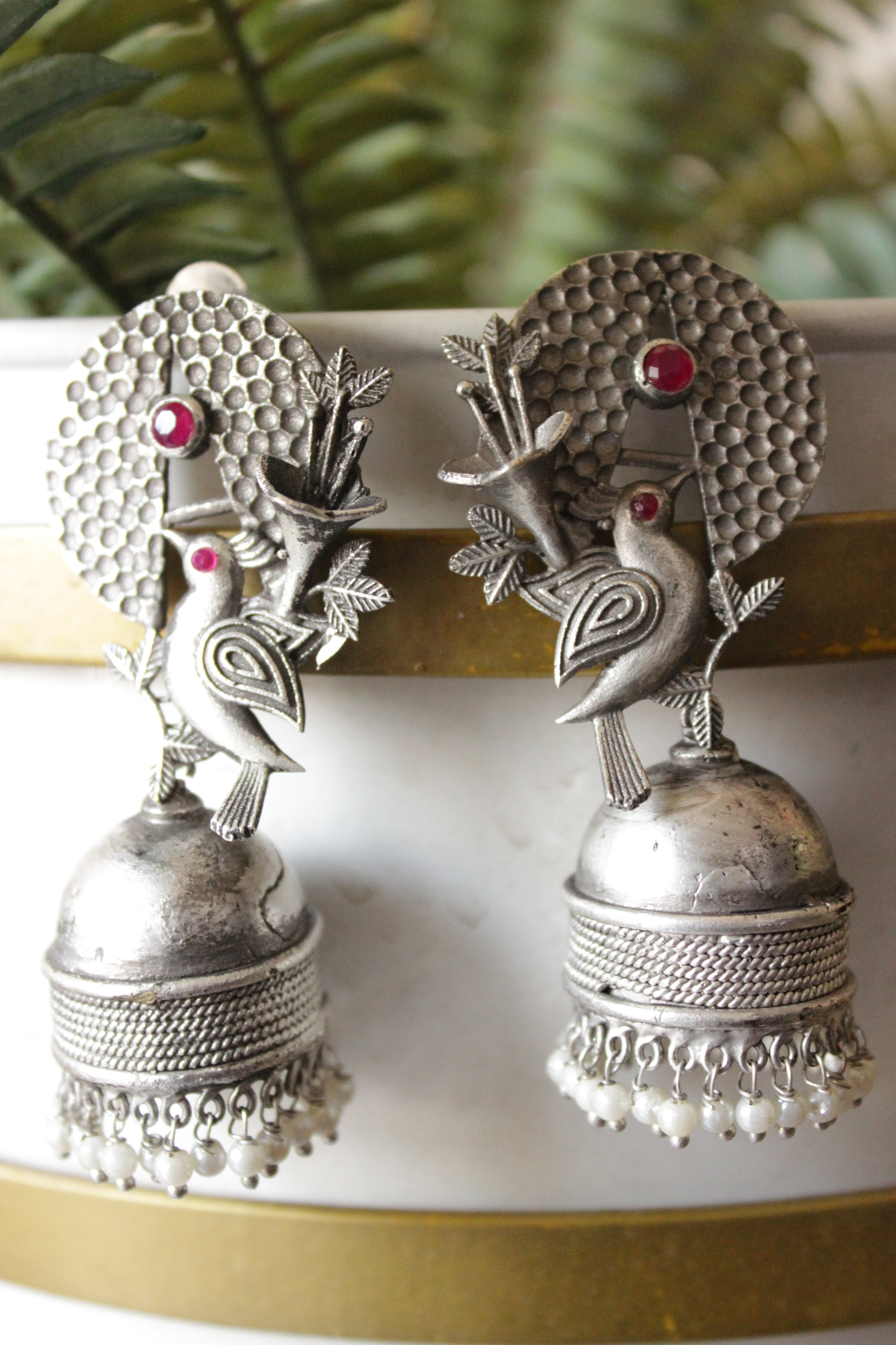 Red Stones Embedded Silver Finish Peacock Motif Statement Jhumka Earrings Accentuated with White Beads