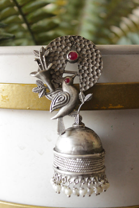 Red Stones Embedded Silver Finish Peacock Motif Statement Jhumka Earrings Accentuated with White Beads