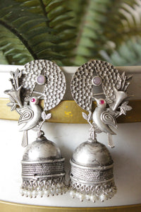 Pink & Red Stones Embedded Silver Finish Peacock Motif Statement Jhumka Earrings Accentuated with White Beads